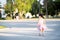 Rear back view of kid girl is jogging in evening at public park. Child wear cloth face mask that can insert filters for PM2.5 dust