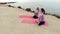 Rear back view women meditate outdoors sit in lotus position on edge of coast near sea, fold fingers mudra gesture do yoga