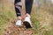 Rear close up view of female step on nature track. Young woman hiking in nature. Adventure, sport and exercise concept