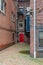 Rear entrance to old brick apartment buildings with red door, fire escape