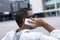 Rear image of young man sitting on a city bench talking on the phone, wearing sunglasses