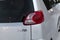 Rear lamp view on the body of a minivan Toyota Porte with with chrome emblem on the trunk of gray color