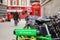 The rear mounted battery of a Lime electric assist rental bike with out of focus traditional red London Double Decker Bus, red