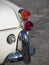 Rear of an old british classic car . Particular view of right tail light and shiny chrome bumper . The car is a Triumph TR3 model