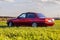 The rear of the old, red, German car that stands on the grass