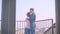 Rear portrait of young caucasian couple in love embraces on balcony and enjoying magnificent city view.
