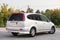 Rear quater view of a Honda Stream car in a silver body Japanese 2002 year van in a parking lot with a green trees and asphalt