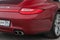 Rear taillamp and exhaust view of car Porsche 911 Carrera 4s with dark gray interior in excellent condition in a parking against