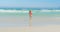 Rear view of active senior African American woman walking towards sea on beach in the sunshine 4k