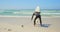 Rear view of active senior Caucasian male surfer standing with surfboard on the beach 4k