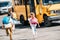 rear view of adorable schoolchildren running to