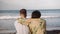 Rear view of affectionate young couple laughing on beach