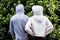 Rear view of african american couple wearing white and grey hooded sweatshirts in garden