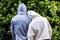 Rear view of african american couple wearing white and grey hooded sweatshirts in garden