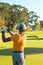 Rear view of african american young man wearing cap hitting with golf club at golf course in summer