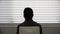 Rear view of anonymous person silhouette sitting on a chair for interview