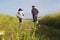 Rear view Asian couple jogging together, outdoor morning run in nature trail organic rice paddy field. Healthy lifestyles and