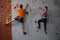 Rear view of athletes rock climbing in club