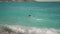 rear view athletic man dives in turquoise water of mediterranean sea in Oludeniz Beach in Aegean Sea and swims. Summer