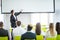 Rear view of Audience in the conference hall or seminar meeting which have Speakers on the stage, business and education about