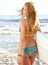 Rear view of beautiful young woman surfer girl in bikini with wh