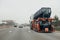 Rear view of a big truck with flatbed trailer hauling tractor ca