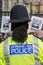 Rear view of black police officer at anti knife crime protest demonstration.