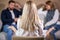 rear view on blond young psychologist woman looking at quarrelled couple sitting opposite