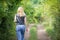 Rear view of blonde woman walking into summer forest