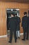rear view of bodyguards and politician standing at elevator