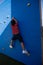 Rear view of boy climbing blue wall at playground