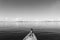 Rear View Of Boy Lying On Boat In Sea Against Sky