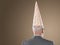 Rear View Of Businessman Wearing Dunce Hat