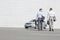 Rear view of businessmen carrying briefcases while walking towards car on street