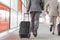 Rear view of businessmen with luggage running on railroad platform