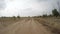 Rear view of car driving along a rural dirt road