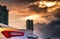 Rear view of car parked in the city near high building after rain with grey and orange sky and clouds and have water droplet