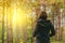 Rear view of casual female looking at sunlight through trees