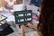 Rear view of caucasian businesswoman analyzing quarterly report over laptop on desk in office