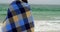 Rear view of Caucasian couple in blanket standing on the beach 4k