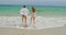 Rear view of Caucasian couple running on the beach 4k
