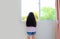 Rear view caucasian little kid girl at home lies at window and watching out