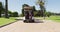 Rear view of caucasian senior couple driving a golf cart with clubs on the back at golf course