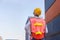 Rear view cheerful female foreman worker in hard hat looking and control loading containers box from cargo