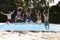 Rear View Of Children Jumping Into Outdoor Swimming Pool