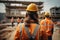 Rear view of civil engineer looking at construction site with building under construction