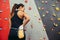 Rear view climber woman rubbing hands with chalk powder from a bag on her waist.