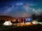 Rear view couple hikers standing near campfire in the camping