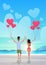Rear view couple holding pink heart shape air balloons sea ocean beach summer vacation concept man woman in love over