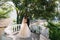 Rear view of a couple of newlyweds hugging in the park. The bride in a black suit and bride in a beautiful white wedding